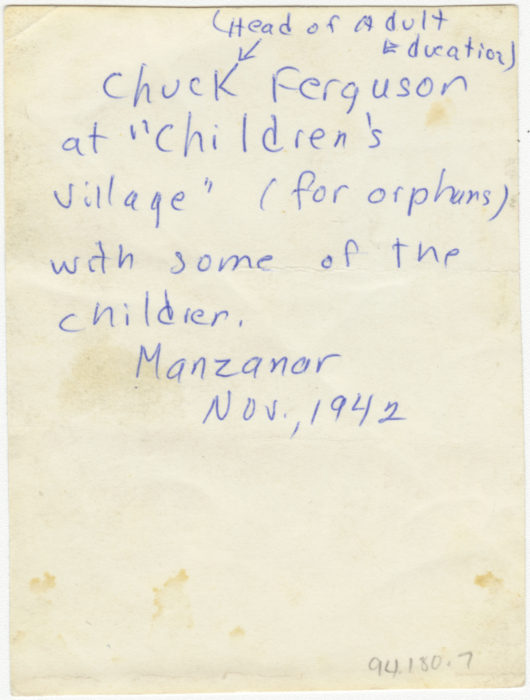 Back of photo, Adult playing with orphan children at Manzanar Camp, Nov 1942